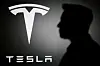 The silhouette of Elon Musk and Tesla logo are seen in this illustration taken on June 11.