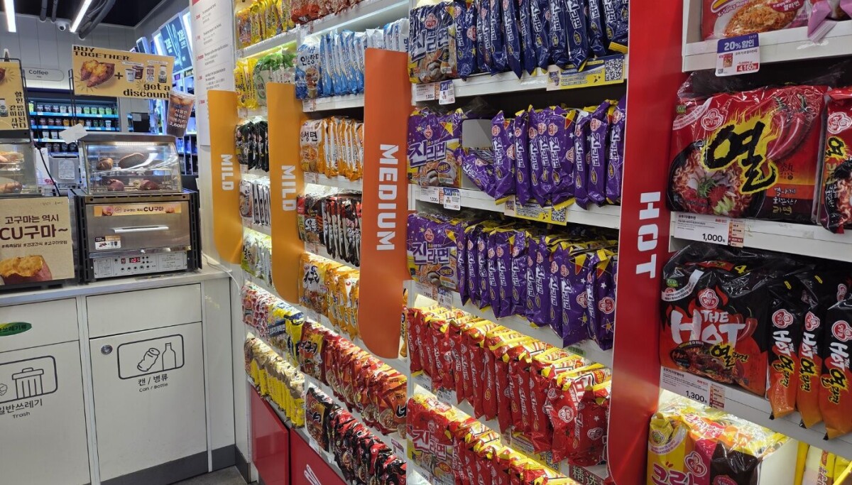 Wall of colorful Korean ramyeon packages sorted by spice level at CU Hongdae Sangsang convenience store in Seoul
