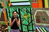 Artist speaking into a microphone in front of a colorful abstract artwork at a museum press event.