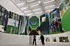 Two visitors stand in a gallery viewing colorful large-scale mural-style artworks at a museum.
