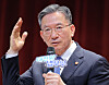 Justice Minister Jung Sung-ho speaks into a microphone at a talk concert, raising one hand.