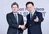 Korean President Lee Jae-myung and OpenAI CEO Sam Altman shake hands in front of a San Francisco backdrop.
