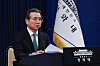 A policy official speaks at a podium beside a South Korean flag in the Blue House press hall.