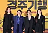 Four actors stand in front of a yellow film backdrop at a movie production event in Seoul.