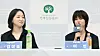 Actress Lee Yeon speaks at a press conference beside another seated woman, with microphones and nameplates on a table.