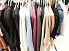 Assorted clothes hanging on a crowded retail rack.