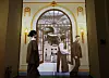 Visitors stand in front of a large historical mural inside a renovated museum gallery.