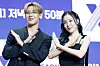BamBam and Tiffany Young pose with crossed arms at a press conference backdrop.