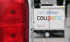 Delivery trucks and a Coupang logo at a logistics center in Seoul.