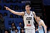 A KCC basketball player in a white jersey points after scoring during a game.