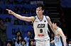 A KCC basketball player in a white jersey points after scoring during a game.