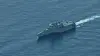 A gray USS Cincinnati warship moves across calm blue water in the South China Sea.