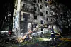 Firefighters spray water on a burning apartment building damaged in a missile attack in Kyiv.