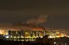 Night view of Kyiv with smoke rising above illuminated buildings after a missile attack.