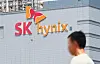 SK hynix logo on a building facade with a blurred person in the foreground.