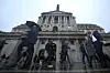 People walk in front of the Bank of England, at the financial district in London, on Feb. 5.