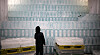 Stacked ice blocks in a Daegu factory with a worker inspecting them before shipment.