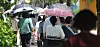 People walk while holding umbrellas to protect themselves from sunlight in Jeonju in North Jeolla on Aug. 3.