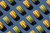 Yellow and green macarons arranged in a repeating diagonal pattern on a blue background.