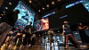 People walk through a cinema lobby as large screens display a promotional video for Christopher Nolan’s Odyssey.