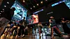 People walk through a cinema lobby as large screens display a promotional video for Christopher Nolan’s Odyssey.