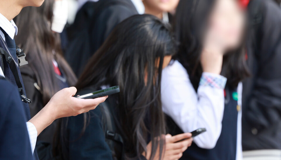 Students use smartphones after their school hours in Seoul on Nov. 4, 2024.