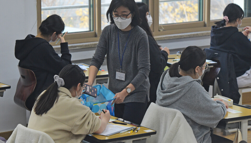 A student submits their cellphone before the nationwide college entrance exam in western Seoul on Nov. 17, 2022.
