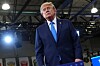 Donald Trump stands beneath industrial lights after speaking at a New York training center.