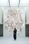 Visitor standing before a large pastel artwork in a bright contemporary gallery.