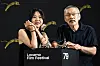 Kim Min-hee and Hong Sang-soo stand behind a Locarno Film Festival podium with awards.
