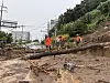 Firefighters rescue a resident whose feet became trapped in mud and debris washed down by torrential rain in Geoje, South Gyeongsang, on Aug. 17.