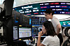 Traders work at the foreign exchange dealing room of the Hana Bank headquarters in Seoul on Aug. 14.