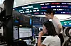 Traders work at the foreign exchange dealing room of the Hana Bank headquarters in Seoul on Aug. 14.