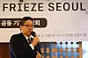Patrick Lee speaks into a microphone beneath a Frieze Seoul press conference backdrop.