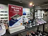 Shoe store display with a Welcome to Korea sign, footwear, accessories, and a small character figure.