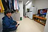 A person sits and watches television at his Haedeunjip unit in Jung District, central Seoul, on Oct. 14, 2025.