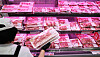 A grocery worker puts packaged samgyeopsal products in a fridge at a supermarket in Seoul on Aug. 25.