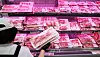 A grocery worker puts packaged samgyeopsal products in a fridge at a supermarket in Seoul on Aug. 25.
