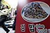 People walk past a gimbap (rice roll) store in central Seoul on Aug. 25.