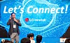 Presenter speaking to an audience before a blue LG Innotek event backdrop.