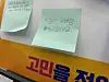 Green sticky notes with Korean handwriting above partially visible colorful Korean lettering.