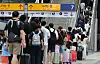 Passengers carrying wheeled suitcases queue to ride the escalator at Seoul Station in central Seoul on Aug. 17