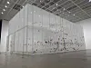 White gallery installation with colorful artworks in a spacious contemporary exhibition hall.
