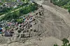 Damaged houses stand precariously near the swollen, debris-choked banks of the Trishuli River after flash floods in Nepal's Nuwakot district on Wednesday, Aug. 26, 2026. (AP Photo/Niranjan Shrestha)/2026-08-27 00:33:25/