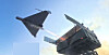 Two military aircraft viewed from below against a bright blue sky.
