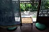 Open hanok doors reveal a garden, low wooden table, and two teal floor cushions.