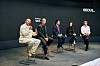 Five panelists sit on a Seoul stage as one man speaks into a microphone.
