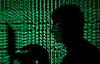 A man holds a laptop computer as cyber code is projected on him in this illustration picture taken on May 13, 2017.