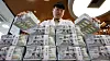 A person holds bundles of dollars at Hana Bank in central Seoul on Aug. 5.