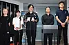 Curator Ruan Yuanlai speaks at a press conference with four people standing beside him.